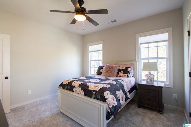 carpeted bedroom with multiple windows and ceiling fan