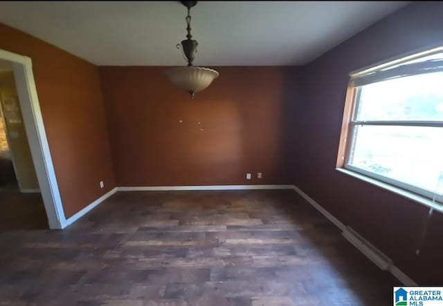 unfurnished dining area featuring baseboard heating and dark hardwood / wood-style floors