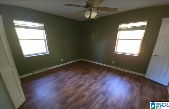 empty room featuring dark wood-type flooring and ceiling fan