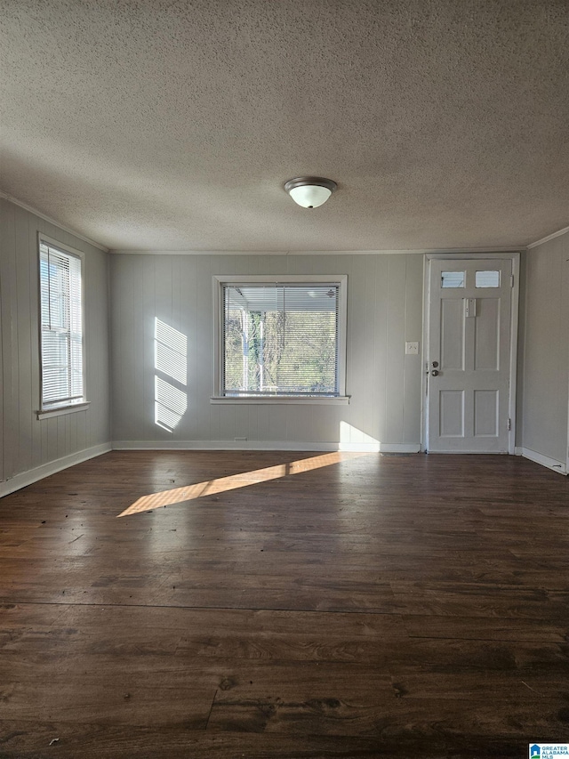 entryway featuring dark hardwood / wood-style flooring, a textured ceiling, and wooden walls