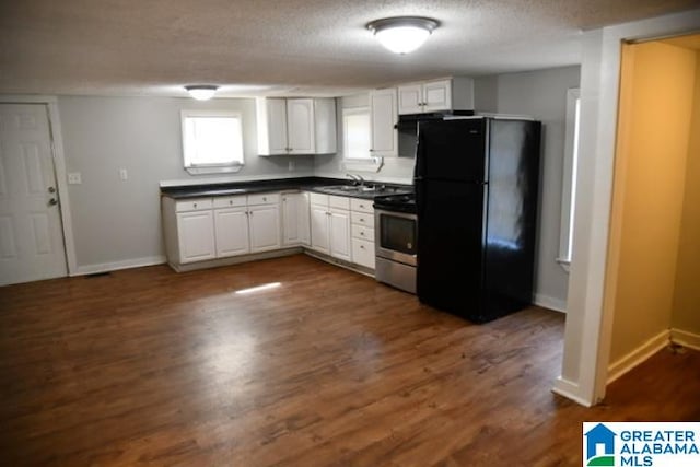 kitchen with black refrigerator, white cabinets, dark hardwood / wood-style floors, and electric stove