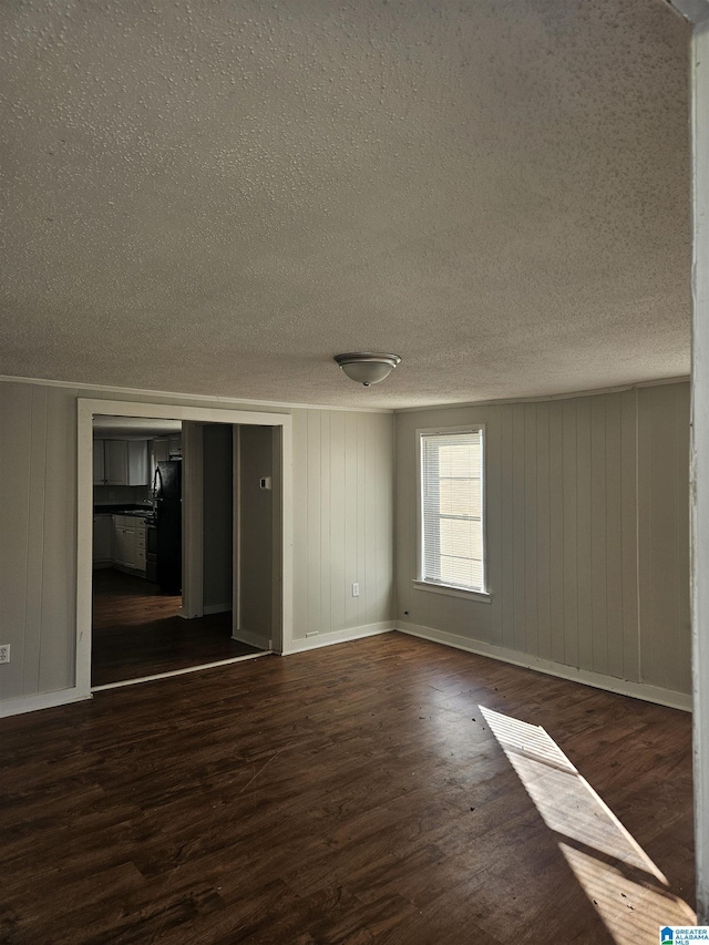 spare room with wooden walls and dark hardwood / wood-style flooring