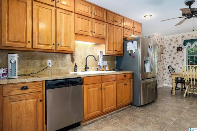 kitchen featuring sink, ceiling fan, stainless steel appliances, crown molding, and decorative backsplash