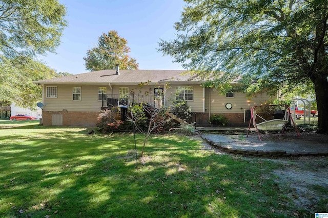 rear view of house featuring a yard and a wooden deck