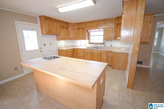 kitchen featuring crown molding, light tile patterned flooring, and sink