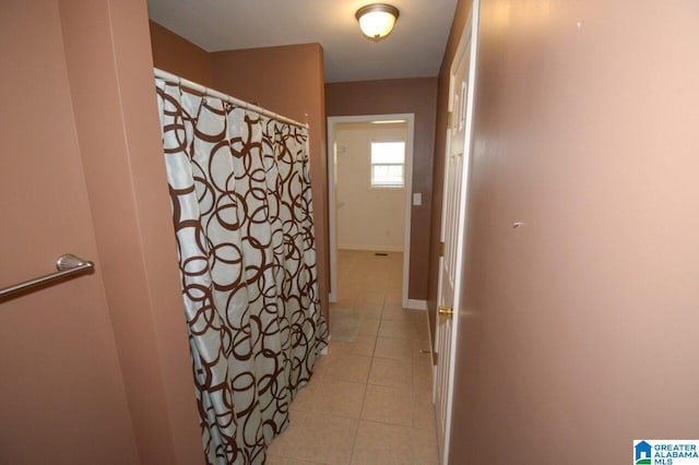 full bathroom with a shower with curtain and tile patterned flooring