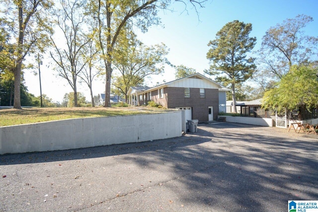 view of property exterior with driveway and brick siding