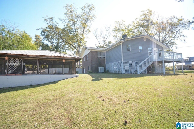 view of home's exterior featuring a wooden deck, central air condition unit, and a lawn