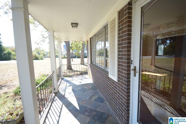 view of patio featuring a water view and a porch