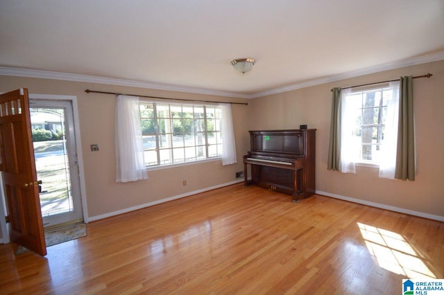 unfurnished living room featuring baseboards, ornamental molding, and light wood-style flooring