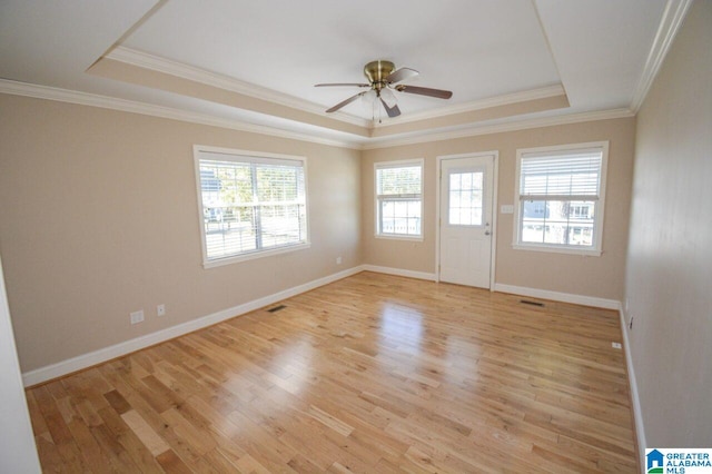 unfurnished room featuring ornamental molding, a tray ceiling, light hardwood / wood-style floors, and ceiling fan