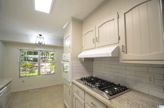 kitchen with white cabinetry, white appliances, light stone counters, and backsplash