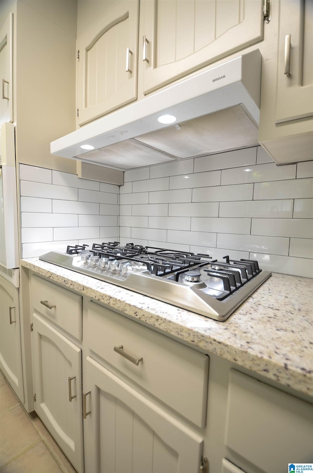 kitchen with cream cabinets, stainless steel gas cooktop, and decorative backsplash