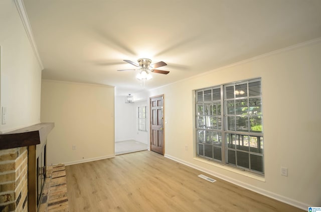 unfurnished living room featuring a brick fireplace, crown molding, light hardwood / wood-style flooring, and ceiling fan with notable chandelier