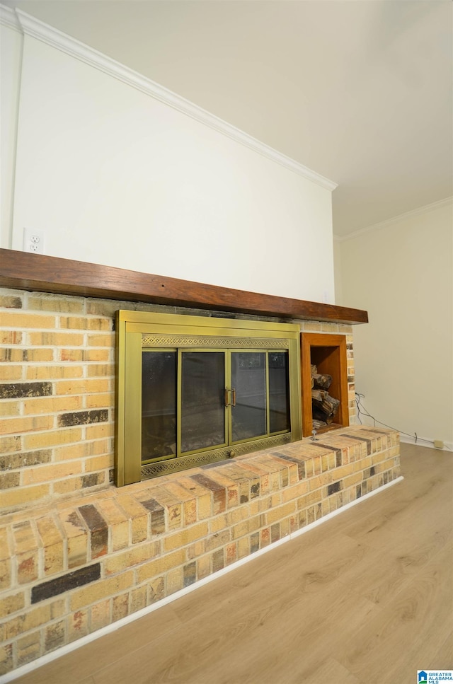 interior details featuring crown molding, a brick fireplace, and hardwood / wood-style flooring