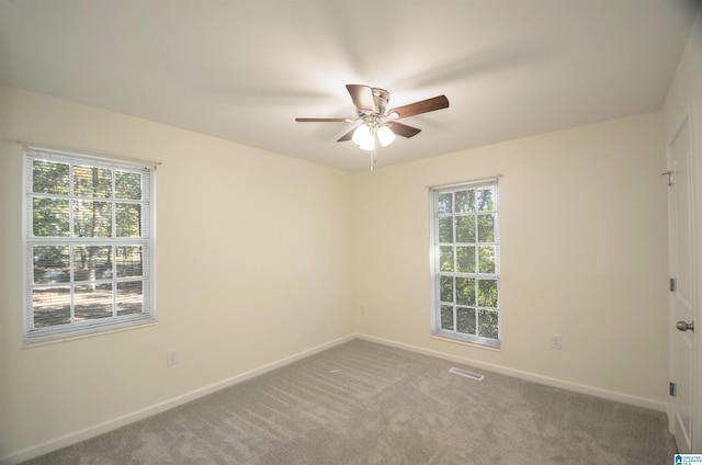 carpeted spare room featuring ceiling fan