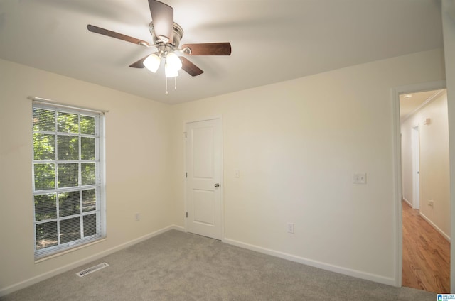 empty room with light colored carpet and ceiling fan