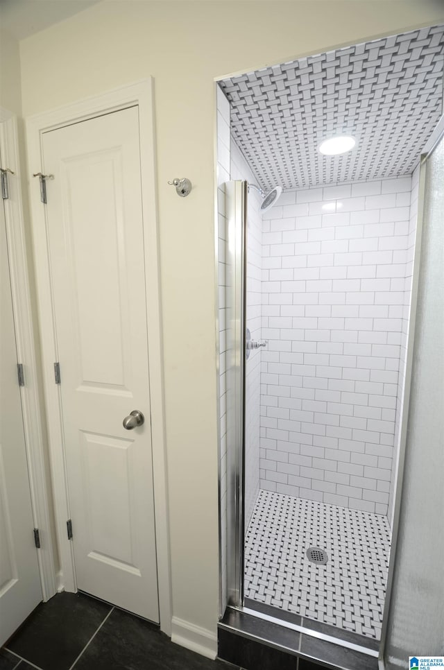 bathroom featuring a shower with door and tile patterned floors