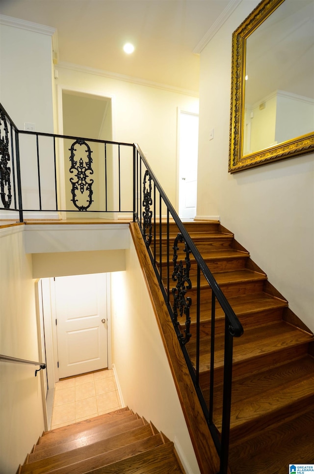 staircase with crown molding and tile patterned floors