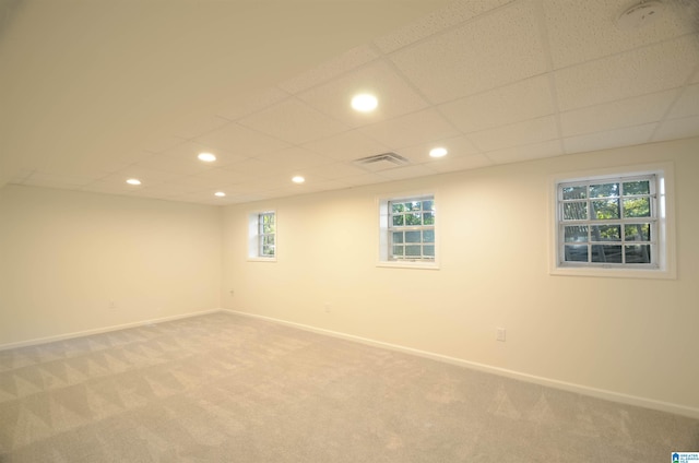 basement with carpet floors and a paneled ceiling