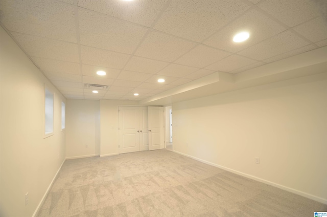 carpeted empty room with a paneled ceiling