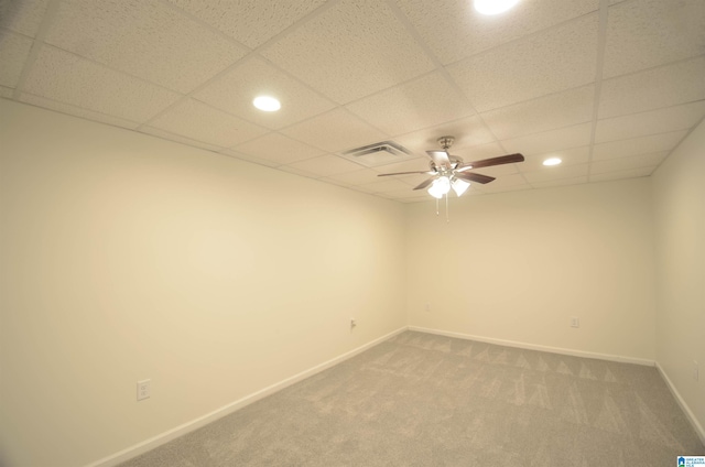 spare room with ceiling fan, carpet floors, and a drop ceiling