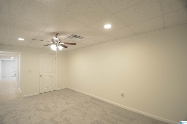 carpeted empty room featuring ceiling fan and a drop ceiling