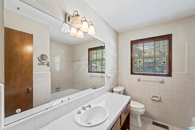 full bathroom featuring vanity, toilet, tile walls, and tile patterned flooring