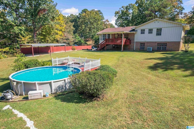 view of swimming pool with central AC, a wooden deck, and a yard