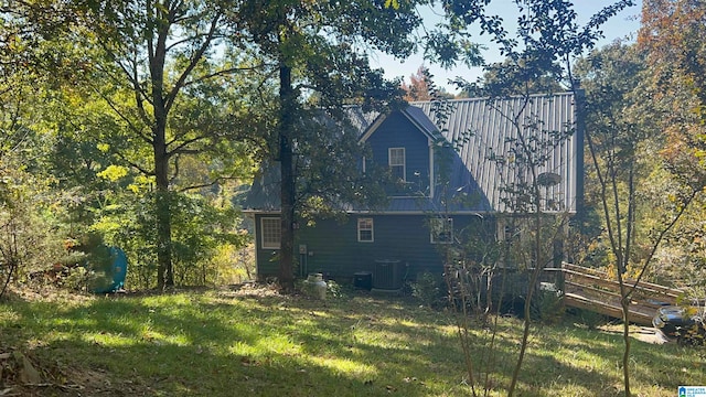 back of house with cooling unit and a lawn