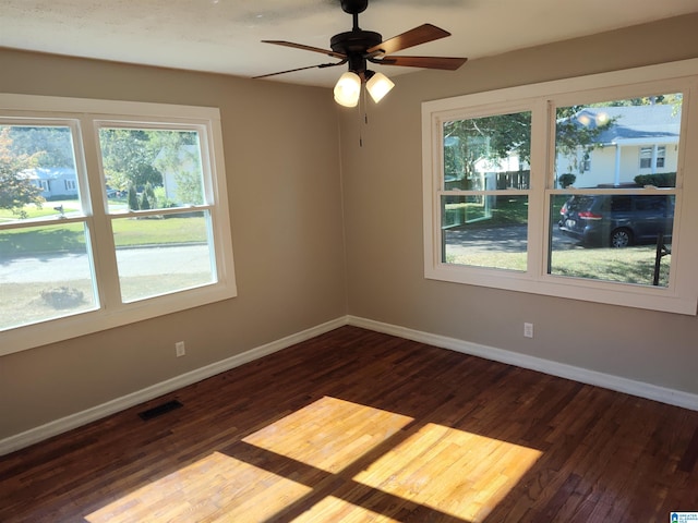 spare room with dark wood-type flooring and ceiling fan