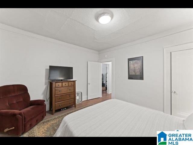 bedroom featuring ornamental molding and a textured ceiling