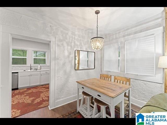 dining area featuring sink, a chandelier, and hardwood / wood-style floors