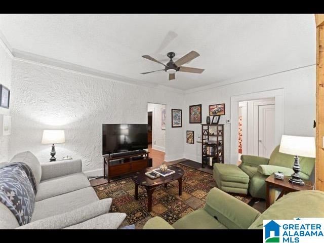 living room featuring crown molding and ceiling fan