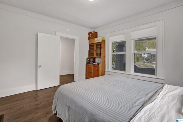 bedroom featuring baseboards, dark wood finished floors, and visible vents
