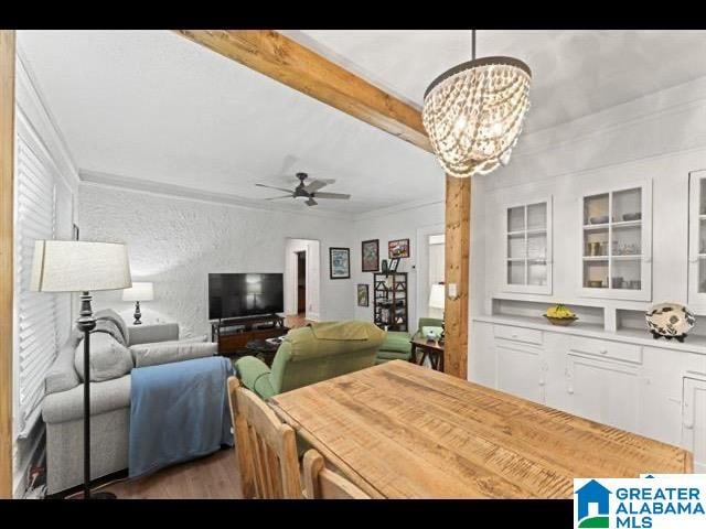 dining area featuring beamed ceiling, ornamental molding, dark hardwood / wood-style floors, and ceiling fan with notable chandelier