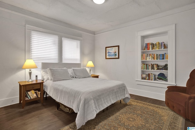 bedroom with baseboards, a textured ceiling, and dark wood finished floors