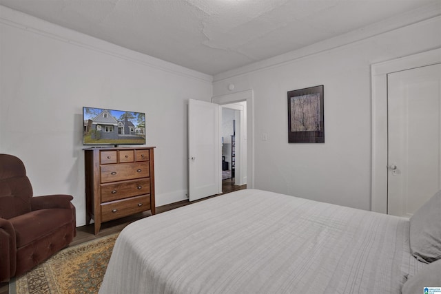 bedroom featuring ornamental molding and wood finished floors