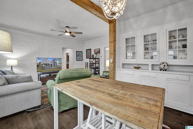 dining area featuring crown molding, a textured wall, ceiling fan with notable chandelier, and dark wood finished floors