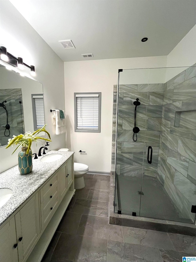 bathroom with vanity, a shower with shower door, and toilet