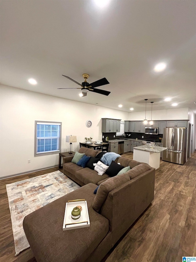 living room featuring ceiling fan and dark hardwood / wood-style flooring