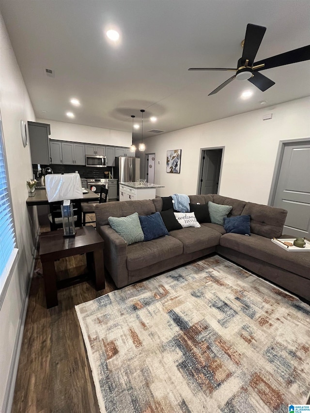 living room featuring ceiling fan and dark hardwood / wood-style flooring