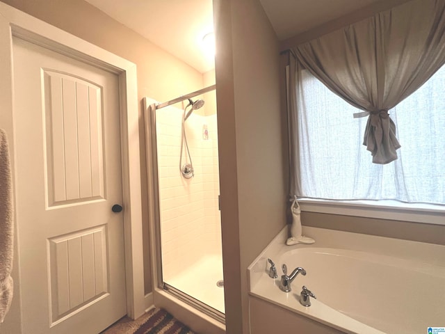 bathroom featuring independent shower and bath