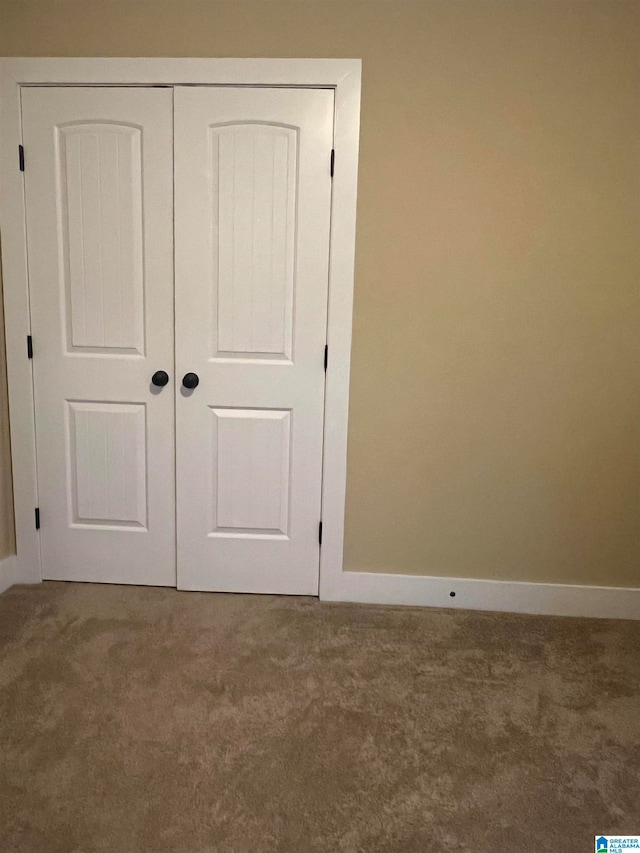 unfurnished bedroom with a closet and carpet flooring