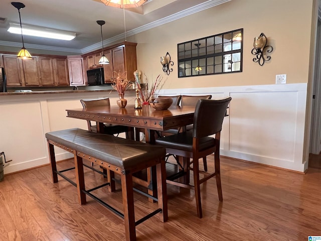 dining area featuring crown molding and hardwood / wood-style floors