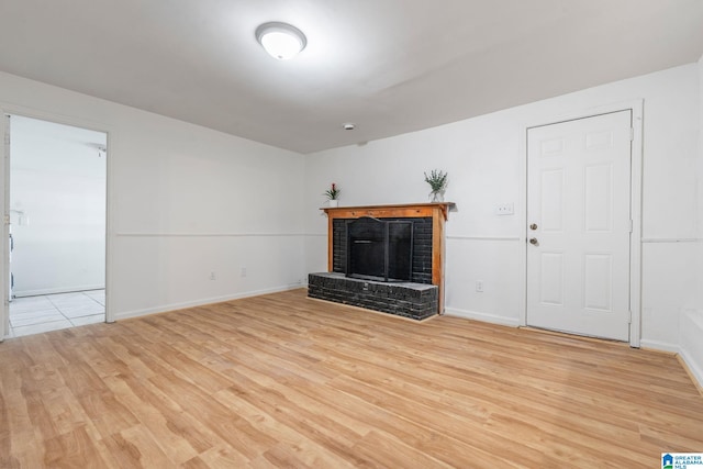 unfurnished living room with light wood-type flooring and a fireplace