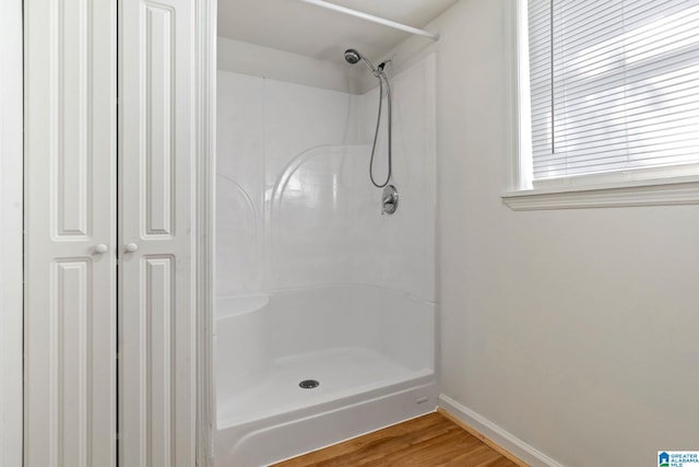 bathroom with hardwood / wood-style flooring and walk in shower