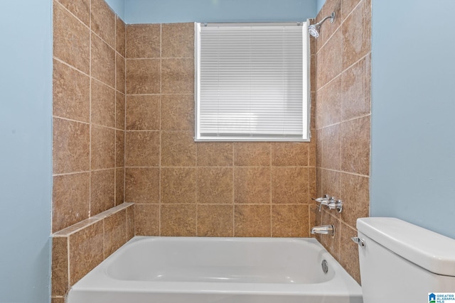 bathroom with toilet and tiled shower / bath combo