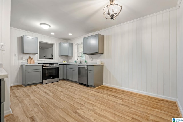 kitchen featuring gray cabinetry, stainless steel appliances, and light wood-type flooring