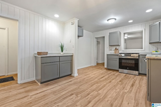 kitchen featuring gray cabinets, light hardwood / wood-style flooring, and stainless steel stove